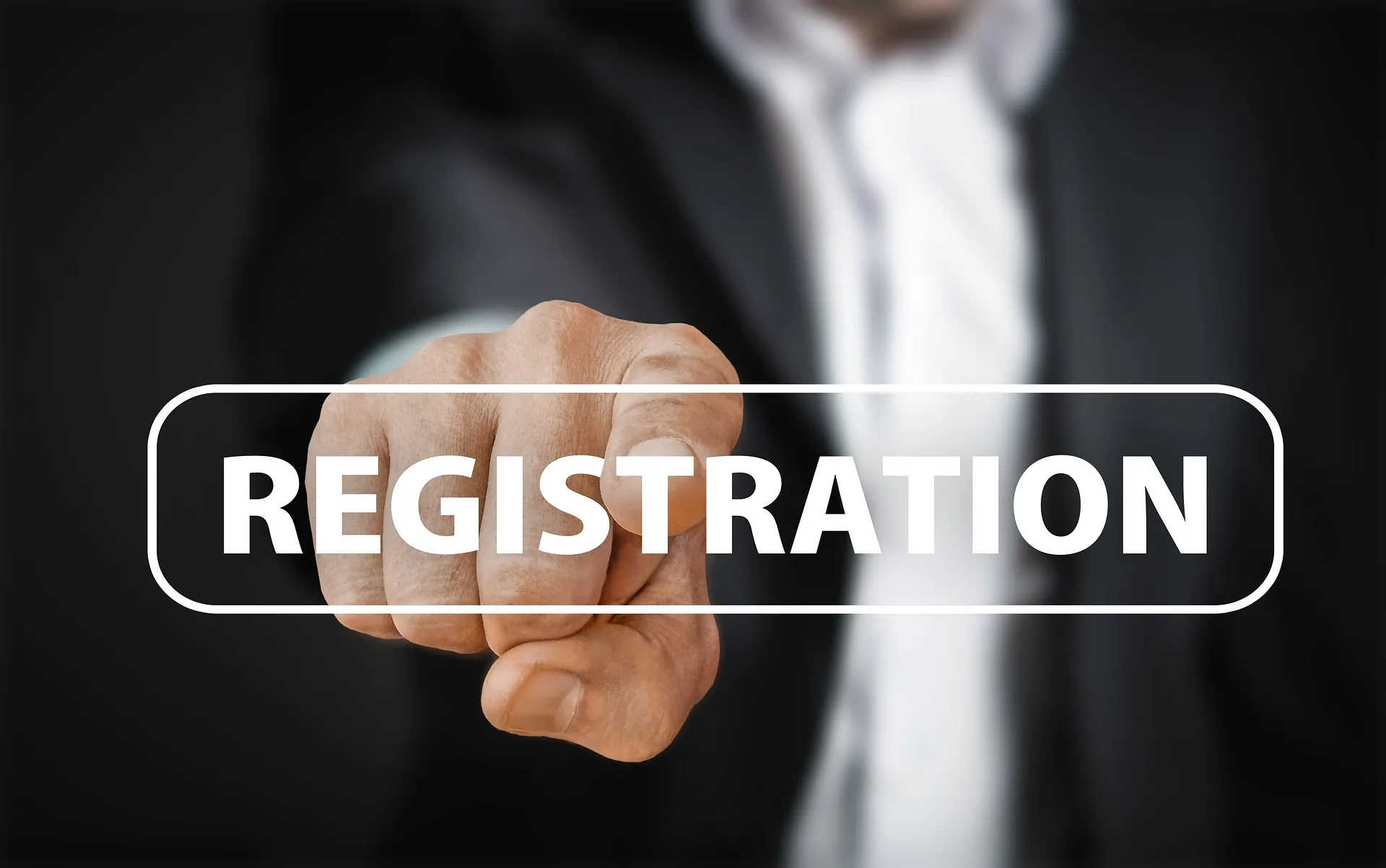 A man in suit pointing his finger in front and a written text of "Registration".